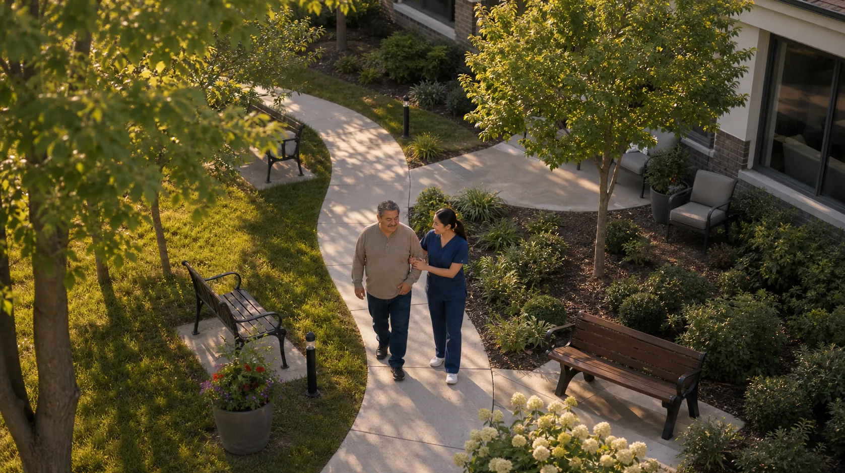 Aerial view of a nurse walking alongside an elderly patient through a sunlit courtyard